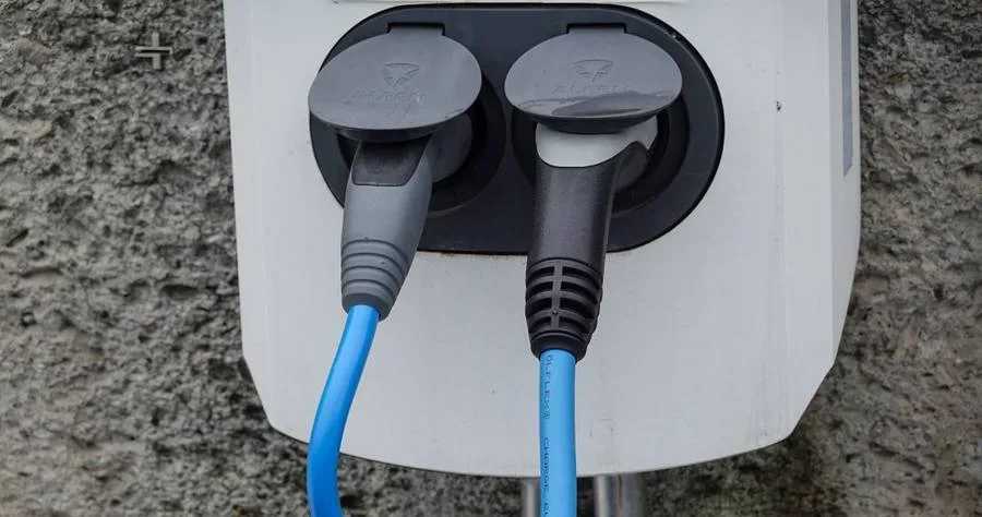 전기차 충전기에 꽂혀 있는 두 개의 충전 케이블
